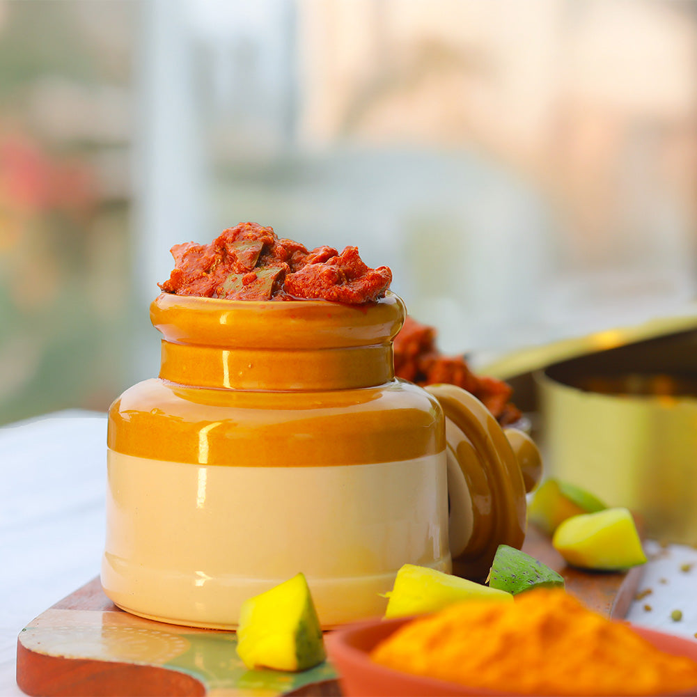 Yellow ceramic jar with red contents on a wooden surface with blurred background