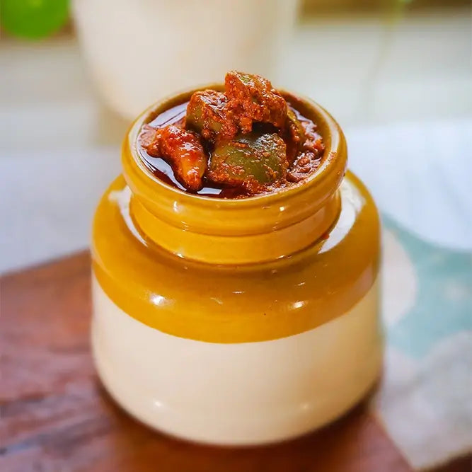 Jar of mango pickle on a wooden surface