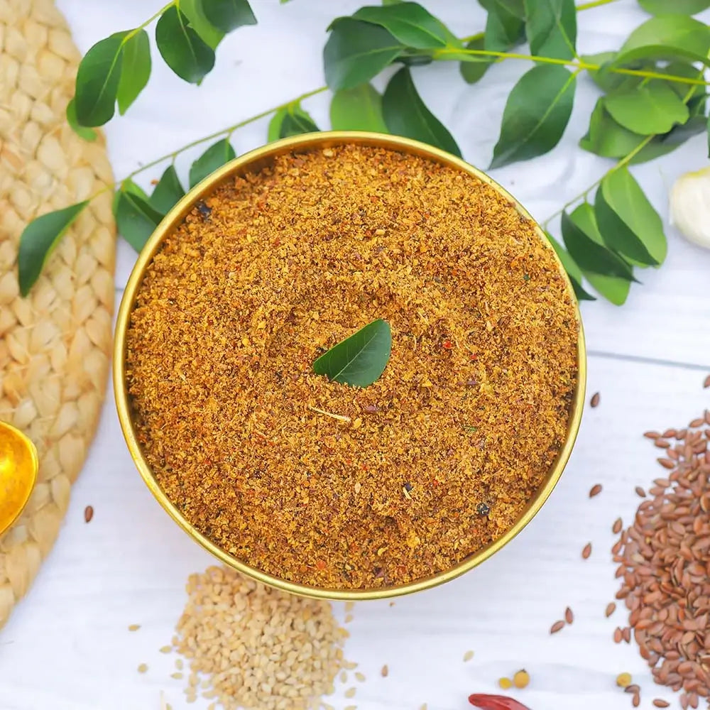 Flax seeds powder in a gold bowl with green leaves on a white background