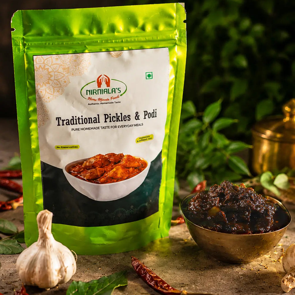 Nirmala's Traditional Gongura pickle in a green resealable pouch, styled on a rustic stone surface with a bowl of dark pickle, garlic, red chilies, and green leaves against a dark green background.