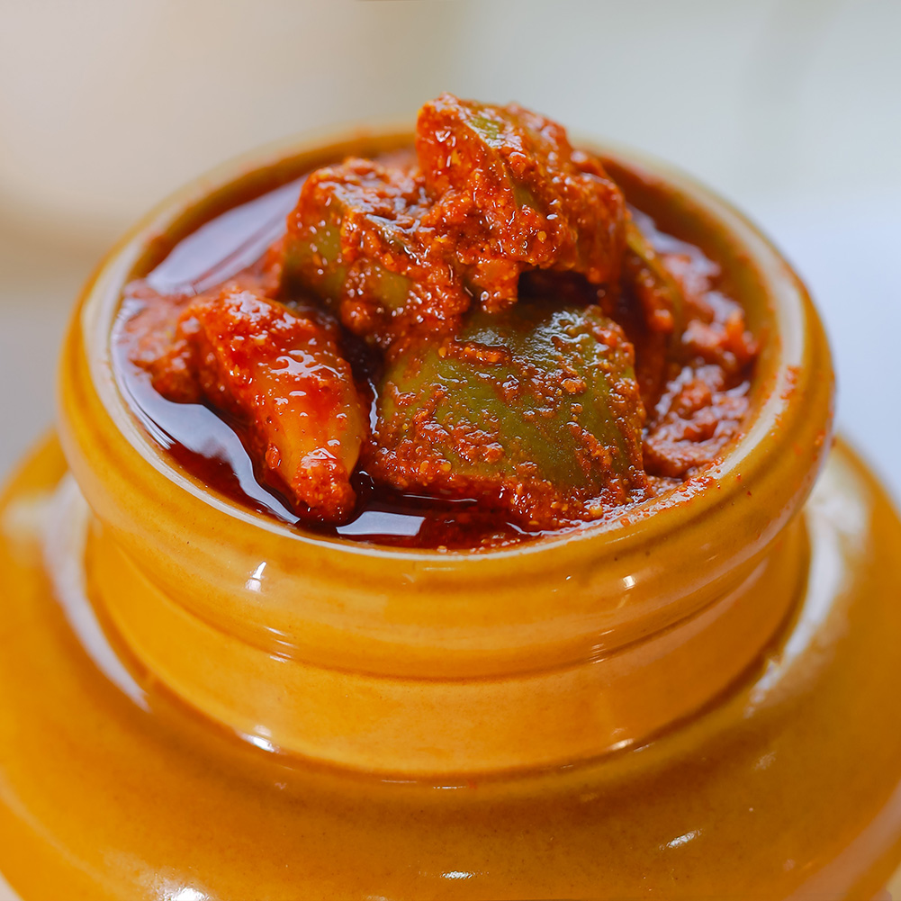 Closeup view of homemade mango pickle with sun-dried mangoes and roasted spices